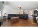 Spacious living room with hardwood floors, a large black sectional sofa, and a view into the kitchen at 12704 Franklin Square Rd, Charlotte, NC 28213