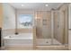 Bright main bathroom with a soaking tub and separate glass enclosed shower at 12704 Franklin Square Rd, Charlotte, NC 28213