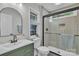 Stylish bathroom featuring a green vanity, modern fixtures, glass shower doors, and natural light at 13115 Meadowmere Rd, Huntersville, NC 28078