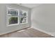 Bright bedroom featuring two windows, and wood look flooring at 13115 Meadowmere Rd, Huntersville, NC 28078