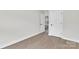 Hallway featuring light wood flooring and white doors leading to various rooms in the home at 13115 Meadowmere Rd, Huntersville, NC 28078