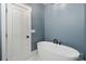 Modern bathroom featuring a freestanding tub, stylish fixtures, and a bright white door at 139 Sheep Path Dr, Mooresville, NC 28115