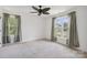 Bright bedroom featuring neutral carpet, two windows with draperies, and a modern ceiling fan at 139 Sheep Path Dr, Mooresville, NC 28115