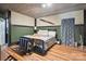Cozy bedroom with wood floors, decorated with an airplane propeller and a comfortable queen-sized bed, inviting relaxation at 139 Sheep Path Dr, Mooresville, NC 28115