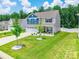 Aerial view of charming two-story home with landscaped yard and driveway at 154 Tanner Loop, Troutman, NC 28166