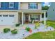 Charming covered front porch with decorative stone accents and front yard landscaping at 154 Tanner Loop, Troutman, NC 28166