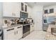Modern kitchen featuring stainless steel appliances, granite countertops, and white cabinets with gold trim at 154 Tanner Loop, Troutman, NC 28166