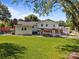 Expansive backyard featuring lush green grass, mature trees, and an outdoor living space at 1632 Kimberly Dr, Gastonia, NC 28052