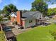 Spacious backyard featuring a patio, well-manicured lawn, brick chimney, and green foliage at 1632 Kimberly Dr, Gastonia, NC 28052