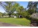 Spacious backyard with mature trees, shed, and storage, creating a serene outdoor space at 1632 Kimberly Dr, Gastonia, NC 28052