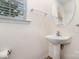 Half bathroom featuring pedestal sink, brushed nickel finishes, and a large round mirror at 17729 Trolley Crossing Way, Cornelius, NC 28031