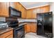 Kitchen featuring wooden cabinets, black appliances, and an open design at 17729 Trolley Crossing Way, Cornelius, NC 28031