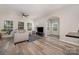 Bright living room with modern ceiling fan, wood floors, and a flood of natural light from the large windows at 17729 Trolley Crossing Way, Cornelius, NC 28031