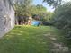Spacious backyard with a storage building, surrounded by lush trees and foliage, offering privacy at 2103 Clawson Ave, Kannapolis, NC 28081