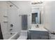 Bathroom with a shower/tub combo, vanity with grey cabinets, and a large mirror at 2273 Aston Mill Pl, Charlotte, NC 28273
