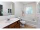 Bright bathroom with a glass block window, a soaking tub, and a vanity with a cherry wood finish at 2273 Aston Mill Pl, Charlotte, NC 28273