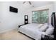 Bedroom featuring a black bed frame with neutral bedding and a large window providing natural light at 2273 Aston Mill Pl, Charlotte, NC 28273