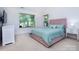 Cozy bedroom with plush pink bed frame, soft green bedding, and natural light from two large windows at 2273 Aston Mill Pl, Charlotte, NC 28273
