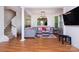 Spacious living room with beautiful hardwood floors, gray sofas, and access to an open staircase at 2273 Aston Mill Pl, Charlotte, NC 28273