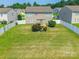 Aerial view of a spacious, fenced backyard and patio, framed by green trees at 2357 Riding Trail Rd, Gastonia, NC 28054