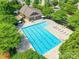 Aerial view of a community pool with lounge chairs and sun umbrellas, surrounded by trees at 2357 Riding Trail Rd, Gastonia, NC 28054
