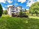 The back of the home features a wooden deck, lush lawn, and mature landscaping at 27246 Preston Pl, Fort Mill, SC 29707