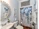 Charming bathroom with decorative mirror, single sink, and shower with a decorative floral curtain at 27246 Preston Pl, Fort Mill, SC 29707