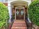 Charming brick home featuring a wooden front door with decorative wreaths and black iron handrails at 27246 Preston Pl, Fort Mill, SC 29707
