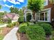 Landscaped front yard featuring a fountain and lush greenery leading to the charming brick home at 27246 Preston Pl, Fort Mill, SC 29707