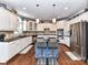 Eat-in kitchen featuring white cabinets, stainless steel appliances, and a blue island with barstool seating at 27246 Preston Pl, Fort Mill, SC 29707