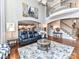 Bright living room featuring a high ceiling, hardwood floors, and a view into the adjacent kitchen at 27246 Preston Pl, Fort Mill, SC 29707