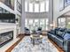 Spacious living room with high ceilings, fireplace, and large windows for ample natural light at 27246 Preston Pl, Fort Mill, SC 29707