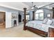Bright main bedroom with sitting area, a large bed, a ceiling fan and natural light through big windows at 27246 Preston Pl, Fort Mill, SC 29707