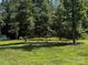 Landscaped backyard featuring mature trees, a green lawn, and a decorative rock border at 2921 Heavners Farm Ct, Lincolnton, NC 28092