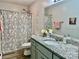Well-lit bathroom featuring granite countertops, floral shower curtain and decorative wall ornaments at 2921 Heavners Farm Ct, Lincolnton, NC 28092