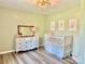 Adorable Bedroom with a white crib, light green walls, vintage dresser, and plenty of natural light at 2921 Heavners Farm Ct, Lincolnton, NC 28092