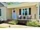 Inviting front porch with rocking chairs, decorative wreath on a pastel door, and beautiful landscaping at 2921 Heavners Farm Ct, Lincolnton, NC 28092