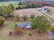 Expansive aerial view of the charming brick home and the surrounding acreage and fall foliage at 3113 Old Pageland Marshville Rd, Wingate, NC 28174