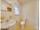 Bathroom featuring a sink, toilet, and window at 3113 Old Pageland Marshville Rd, Wingate, NC 28174