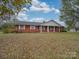 Inviting brick home showcasing a well-maintained lawn, crisp white trim, and covered front porch at 3113 Old Pageland Marshville Rd, Wingate, NC 28174