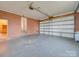 Spacious garage featuring a red brick wall, a large roll-up door, and ample room for parking at 3113 Old Pageland Marshville Rd, Wingate, NC 28174