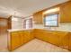 Traditional kitchen with wooden cabinets, laminate countertops, and wood-look flooring at 3113 Old Pageland Marshville Rd, Wingate, NC 28174