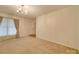 Neutral living room with carpet, showcasing a chandelier and large window for ample natural light at 3113 Old Pageland Marshville Rd, Wingate, NC 28174