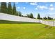 Expansive backyard featuring a pristine lawn, framed by a white fence, and mature trees at 3835 Norman View Dr, Sherrills Ford, NC 28673