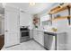 Bright kitchen featuring updated appliances, marble countertops, and open shelving at 404 Wakefield Dr # C, Charlotte, NC 28209