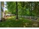 Lush backyard showcasing a pergola-covered patio, grilling area, and expansive green space with mature trees at 512 Veloce Trl, Fort Mill, SC 29715