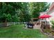 Spacious backyard featuring a patio with grilling area, pergola, dining set, and white picket fence at 512 Veloce Trl, Fort Mill, SC 29715