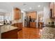 Well-lit kitchen with stainless steel refrigerator, granite countertops, and hardwood flooring at 512 Veloce Trl, Fort Mill, SC 29715