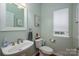 Well-lit powder room featuring modern fixtures, light green paint, and a window at 512 Veloce Trl, Fort Mill, SC 29715