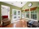 Charming sunroom with lots of windows, hardwood floors, and comfortable seating by the French doors at 512 Veloce Trl, Fort Mill, SC 29715